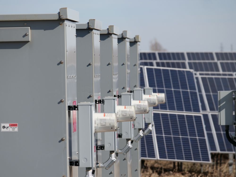 Electrical inverter enclosures installed beside a solar panel array