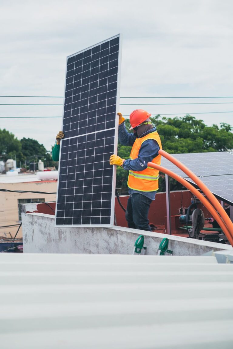 Installer in safety gear placing a panel on a rooftop