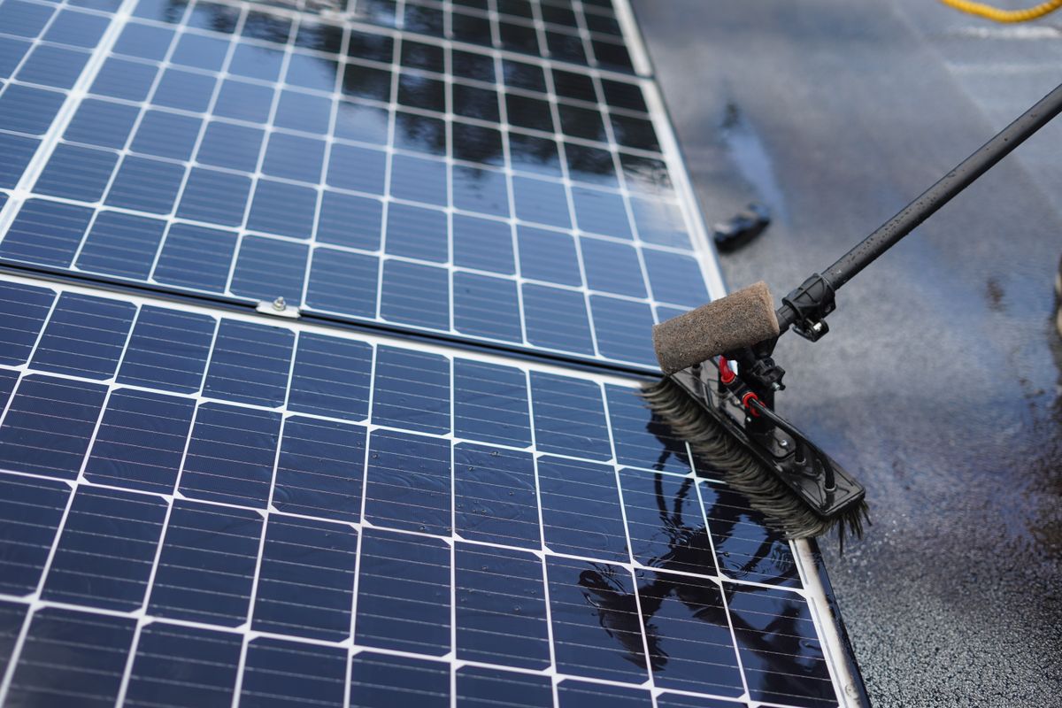 Close-up of a soft brush cleaning the surface of a solar panel