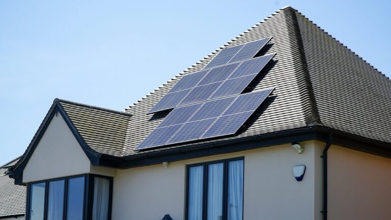 White house with dark solar panels on a pitched roof